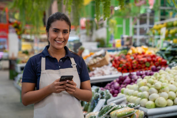 istock Retail clerk using her cell phone while working at the supermarket 2172032069