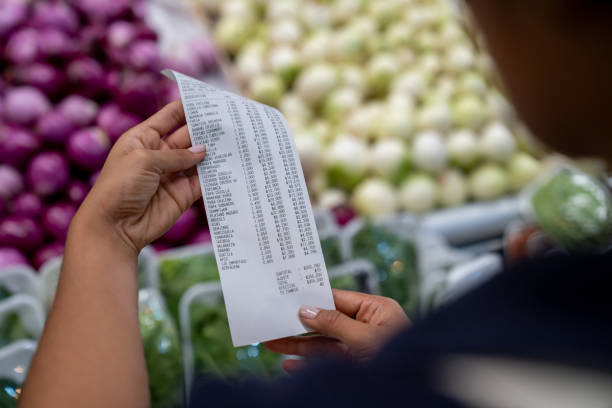istock Woman checking a receipt while shopping at a greengrocer's shop 2172032101