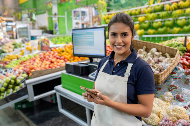 istock Market vendor using a cell phone while working at the greengrocer's shop 2172032141