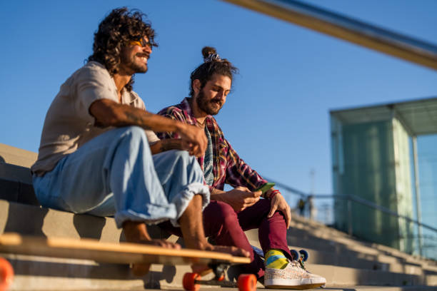 istock Joyful Male Friends Relaxing with Longboards 2172032990