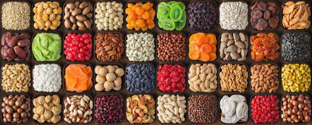 istock colorful dried fruits, assorted nuts and seeds background. mixed raw food for snacking, top view. 2172036718
