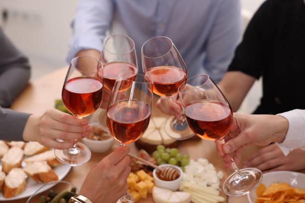 istock People clinking glasses with rose wine above table indoors, closeup 2172040555