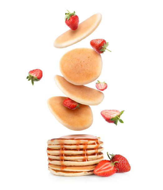 istock Many fresh pancakes and strawberries falling onto stack against white background 2172041136