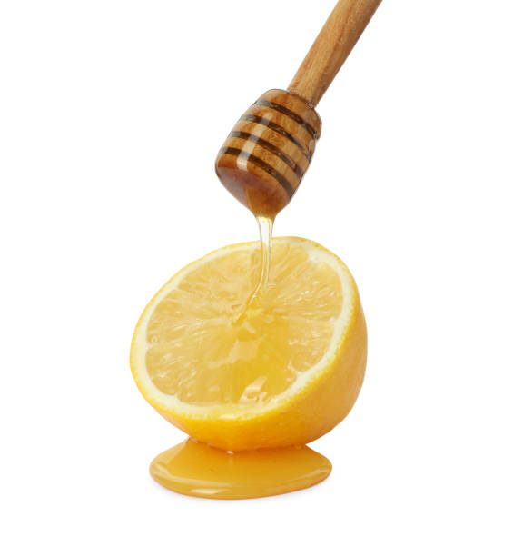 istock Dripping sweet honey from dipper onto fresh lemon on white background 2172041311