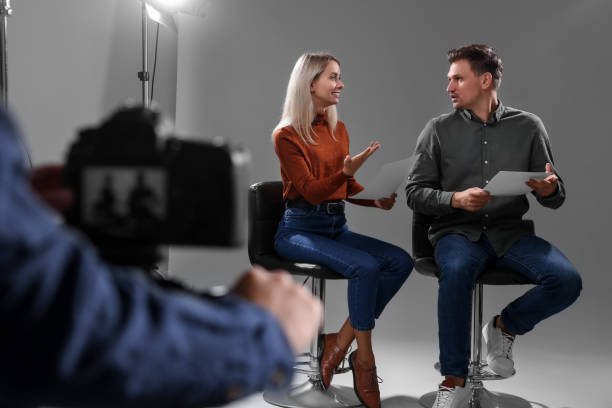 istock Casting call. Man and woman performing while camera operator filming them against grey background in studio 2172042997