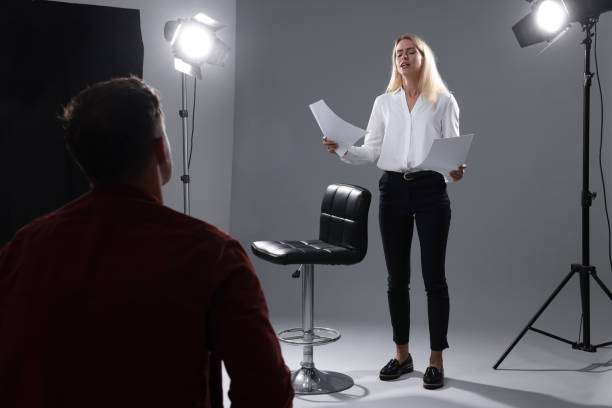 istock Emotional woman with script performing in front of casting director against grey background in studio 2172043039