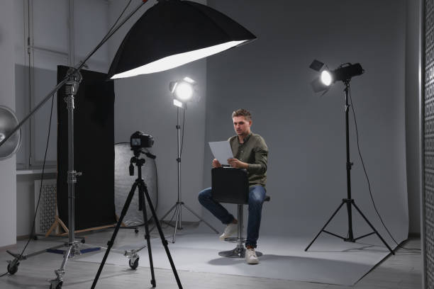 istock Casting call. Man with script sitting on chair and performing in front of camera in studio 2172043041