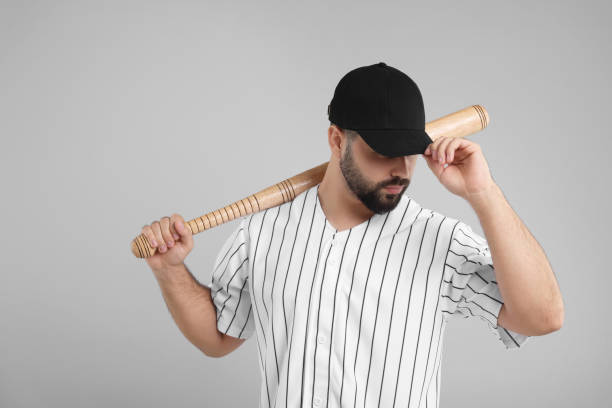 istock Man in stylish black baseball cap holding bat on light grey background 2172044450