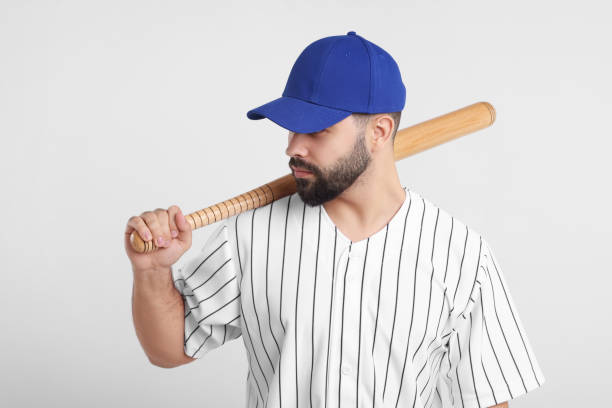 istock Man in stylish blue baseball cap holding bat on white background 2172044481