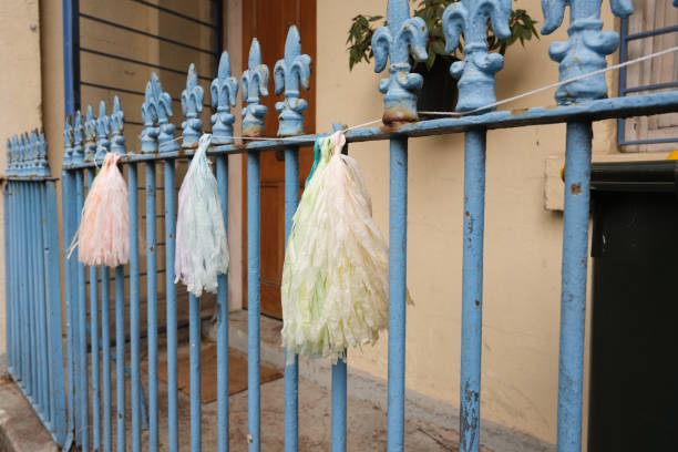 Paper decorations on an old rusting wrought iron fence.