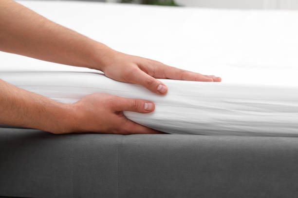 istock Man putting bed sheet on soft mattress, closeup 2172047731