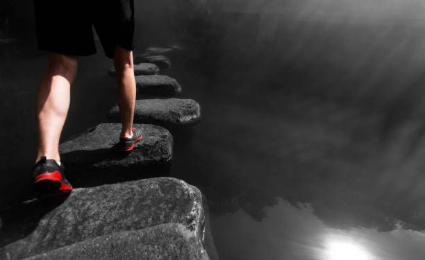 istock Man walking crossing river on stones bridge 2172049318