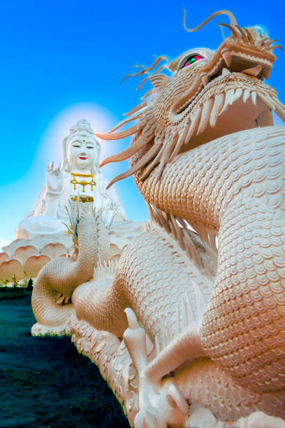 istock White Guan Yin statue and big dragon statue 2172055662