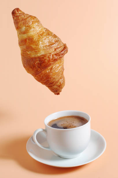 istock Croissant hanging over coffee 2172065013