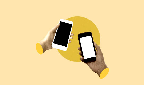 istock Two hands holding mobile phones with black screen isolated on yellow background. Art collage digital pop modern art 2172065626