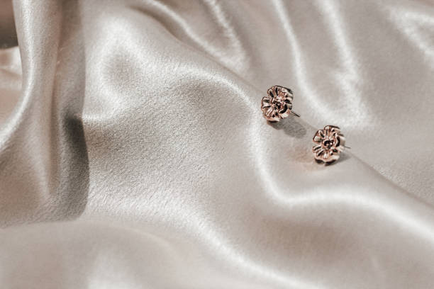istock Gold earring decoration on golden silk fabric with space for text 2172067265