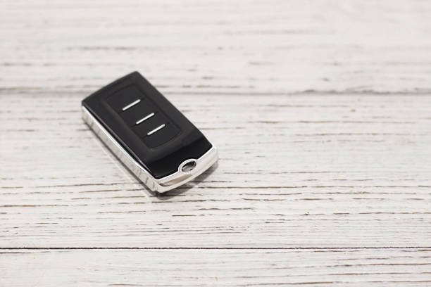 car keys, remote control on a wooden background