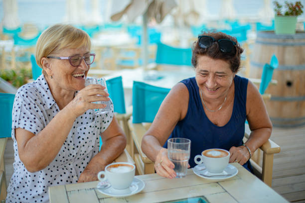 istock Two female senior friends having a coffee at a beach bar 2172070537
