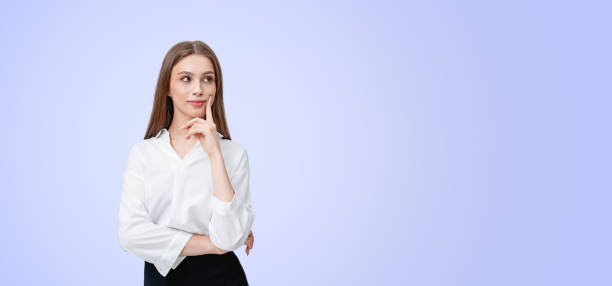 istock Thoughtful woman with a smile in white shirt on light blue backg 2172073214