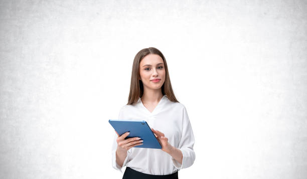 istock Woman holding a tablet against a light background. 2172073319