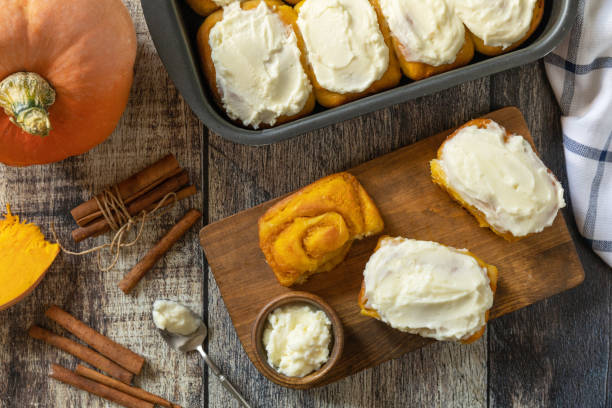 istock Freshly baked pumpkin cinnamon rolls or cinnabon with cream cheese on a rustic wooden table. Homemade seasonal autumn homemade pastry. 2172075779