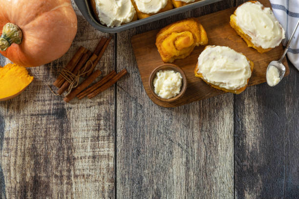 istock Freshly baked pumpkin cinnamon rolls or cinnabon with cream cheese on a rustic wooden table. Homemade seasonal autumn homemade pastry. 2172075785