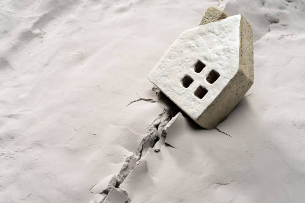 Miniature house on cracked ground