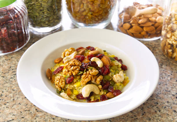 Rice flour or khao Mao mixed with corn topped with almonds Cashews, walnuts, cranberries and raisins in a white plate, food background