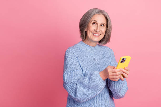 istock Photo of dreaming hold phone looking empty space advertisement wear blue pullover advert app for remote video calls isolated on pink color background 2172097132