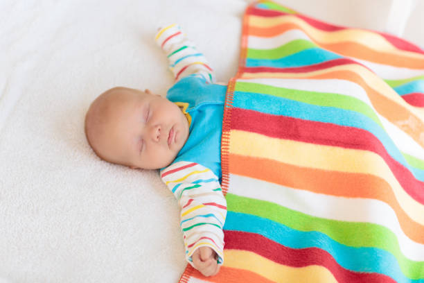 Beautiful baby boy sleeping covered with soft blanket