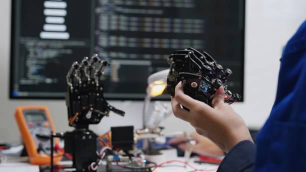 The eletrcial engineer use the computer coding for input program to bluetooth remote control circuit board in order to command simulation robot hand. The eletrcial engineer use the computer coding for input program to bluetooth remote control circuit board in order to command simulation robot hand. input output pictures stock pictures, royalty-free photos & images