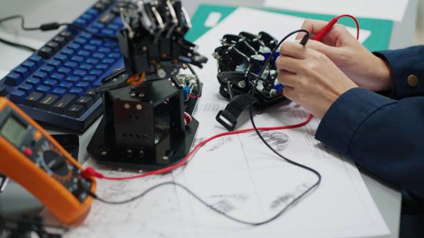 istock Close up shot at hand of Electrical engineer testing voltage with a digital multi-meter on a curcuit board of robotics hand in assemblies room. 2172101062