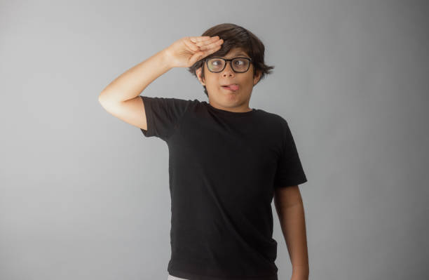Young multiracial boy Indian-Iranian looking at camera making faces and gestures