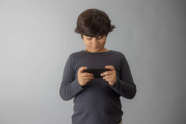 Young multiracial boy Indian-Iranian playing a game on his phone
