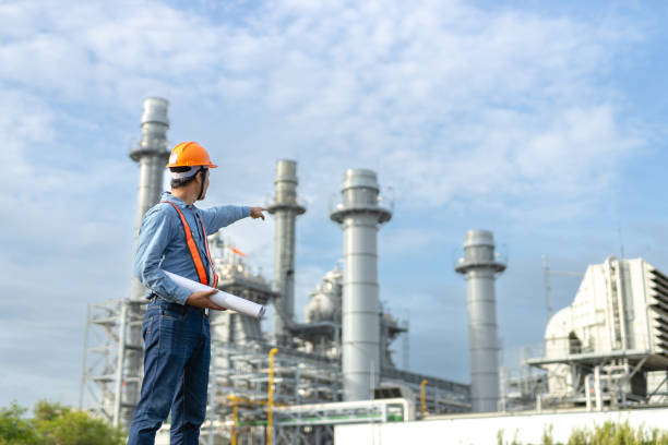 istock Asian worker power plant factory holding blueprint pointing check construction plan power plant. Engineer wearing safety uniform helmet at energy petrochemical industry. 2172102622