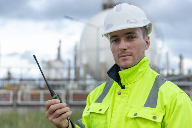 istock Man professional engineer technician wear safety uniform and white hard hat working area near tank refining oil petrochemical industry factory. Industrial factory site energy power station. 2172104886