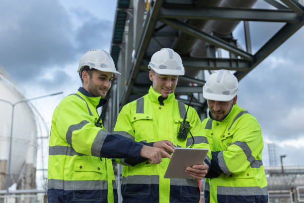istock Team professional electrical engineer safety uniform working together at station refining oil petrochemical using tablet. Industrial factory site control energy power station. 2172104922
