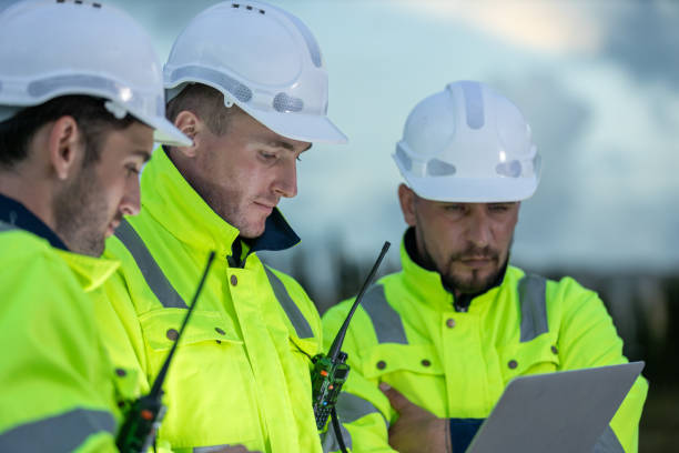 istock Team professional electrical engineer safety uniform working together power plant using laptop during evening time. Industrial engineering factory site control energy power station and oil. 2172105058