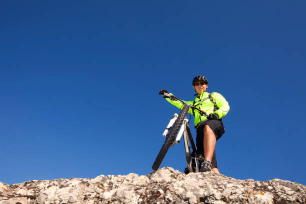 Color image depicting the blurred motion of a man riding his mountain bike on a rural forest path. The long exposure emphasises the speed of the bike.