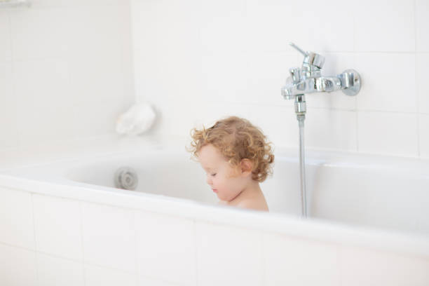 istock Little baby in bath tub playing with soap foam 2172108017