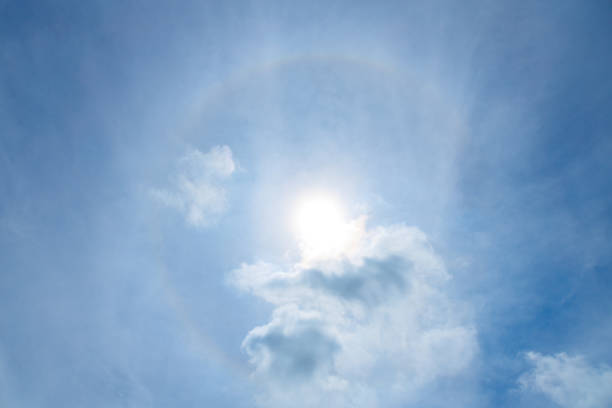Scenic sunbeams through the clouds with circular rainbow in the blue sky, Cloudscape