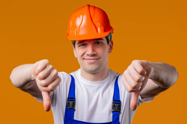 istock Mature 30s builder foreman with dislike.Handyman expresses thumbs-down on orange 2172124221