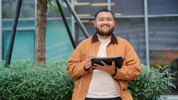 Portrait of asian man using tablet during break