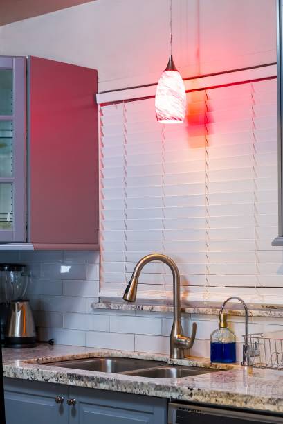 istock Modern kitchen with granite countertop and red pendant light. 2172127712