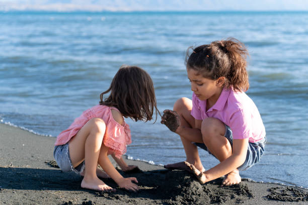 istock Children playing with sand by the sea. 2172134524