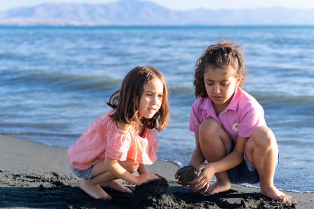 istock Children playing with sand by the sea. 2172134530