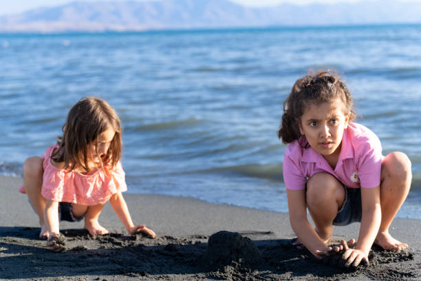 istock Children playing with sand by the sea. 2172135094