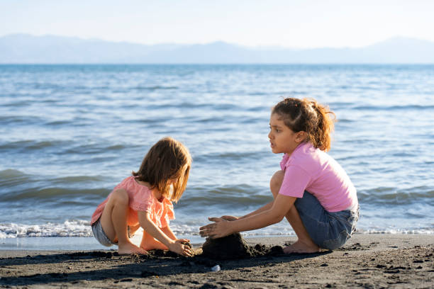 istock Children playing with sand by the sea. 2172135109