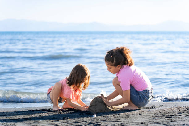 istock Children playing with sand by the sea. 2172135122