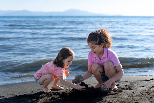 istock Children playing with sand by the sea. 2172135278